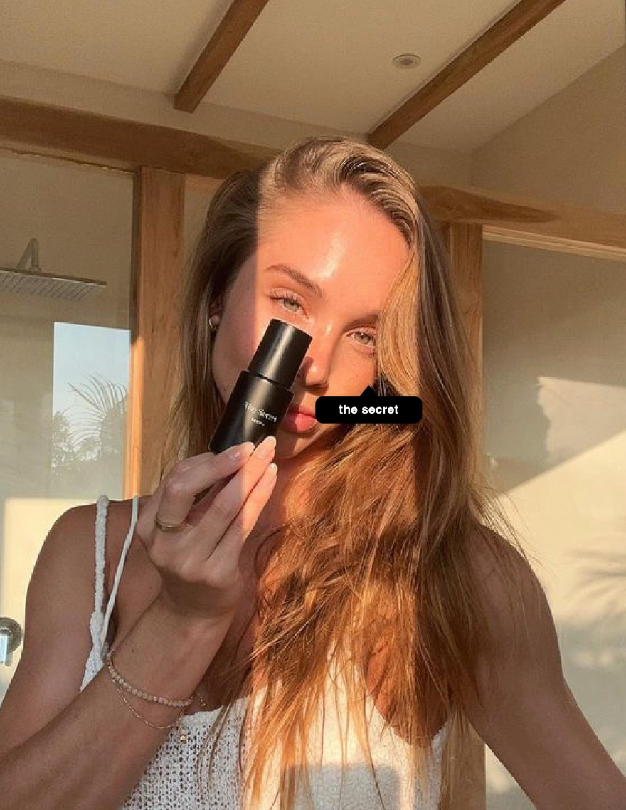 young female under the sun holding The Secret’s Solar Serum SPF50