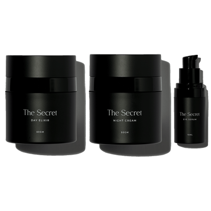 A anti ageing skincare set of three skincare products from The Secret brand, including a day elixir, night cream, and an eye product, all in black packaging.