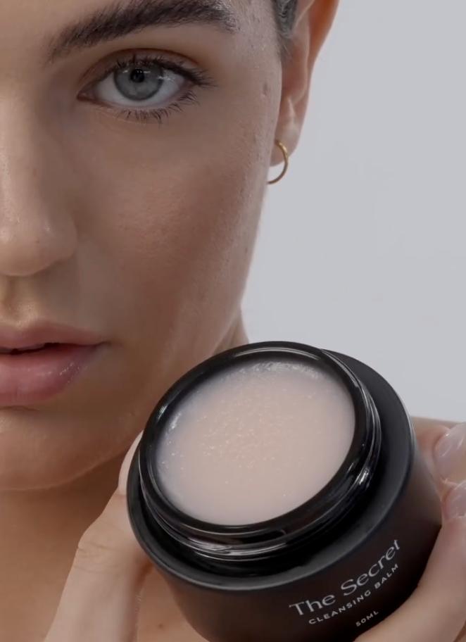 A model holding Secret Skincare product, illustrating the question: Do you exfoliate or cleanse first?